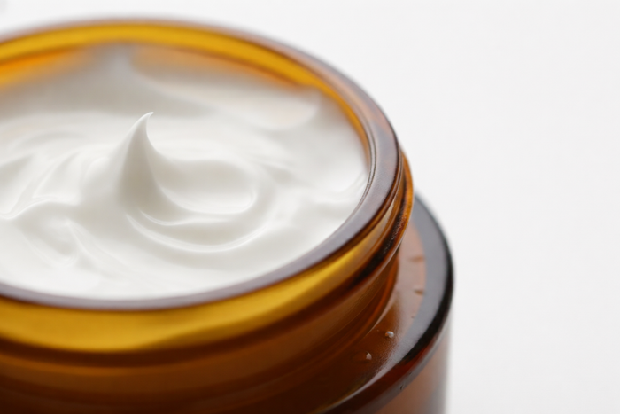 Close-up of a jar of white cream with a white background