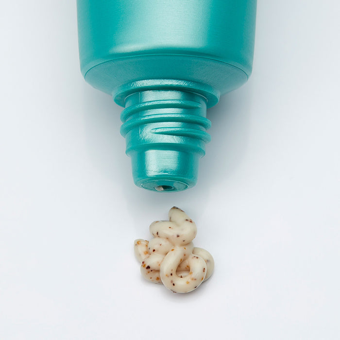 Close-up of a teal tube dispensing creamy exfoliating cream with natural grainy texture from Cyfolia Organic - Radiance Exfoliating Cream | Phytomer, skincare product.
