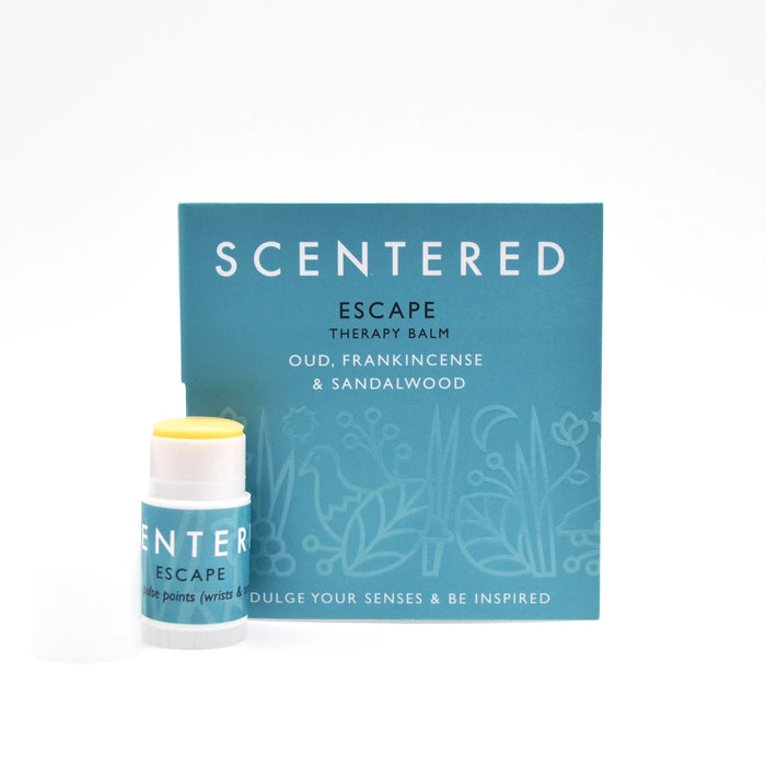 Escape Mini Aromatherapy Balm | Scentered in blue packaging with the balm stick partially open showing yellow balm, featuring scents of oud, frankincense, and sandalwood for skincare and wellness.