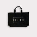 Black canvas tote bag with double handles and zipper top featuring the word RELAX inside a white rectangular outline, Relax Tote Bag w/ Zipper Top | Lucky Owl